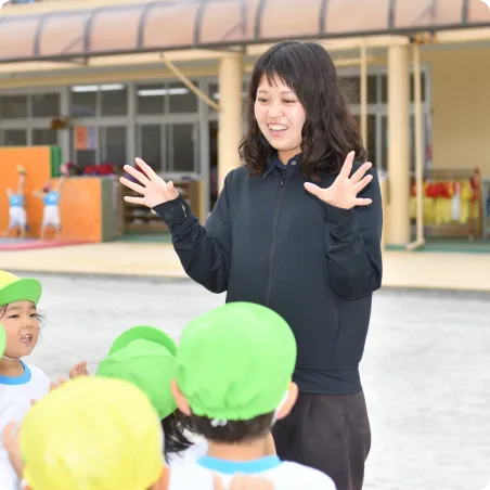 園庭で子どもたちに話しかける先生