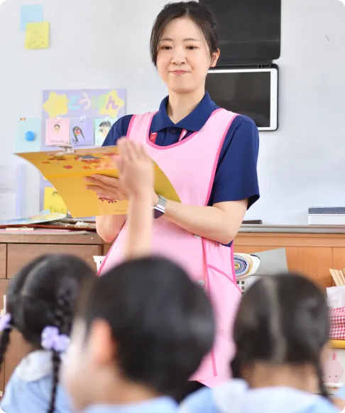 子どもたちに絵本を読み聞かせる先生
